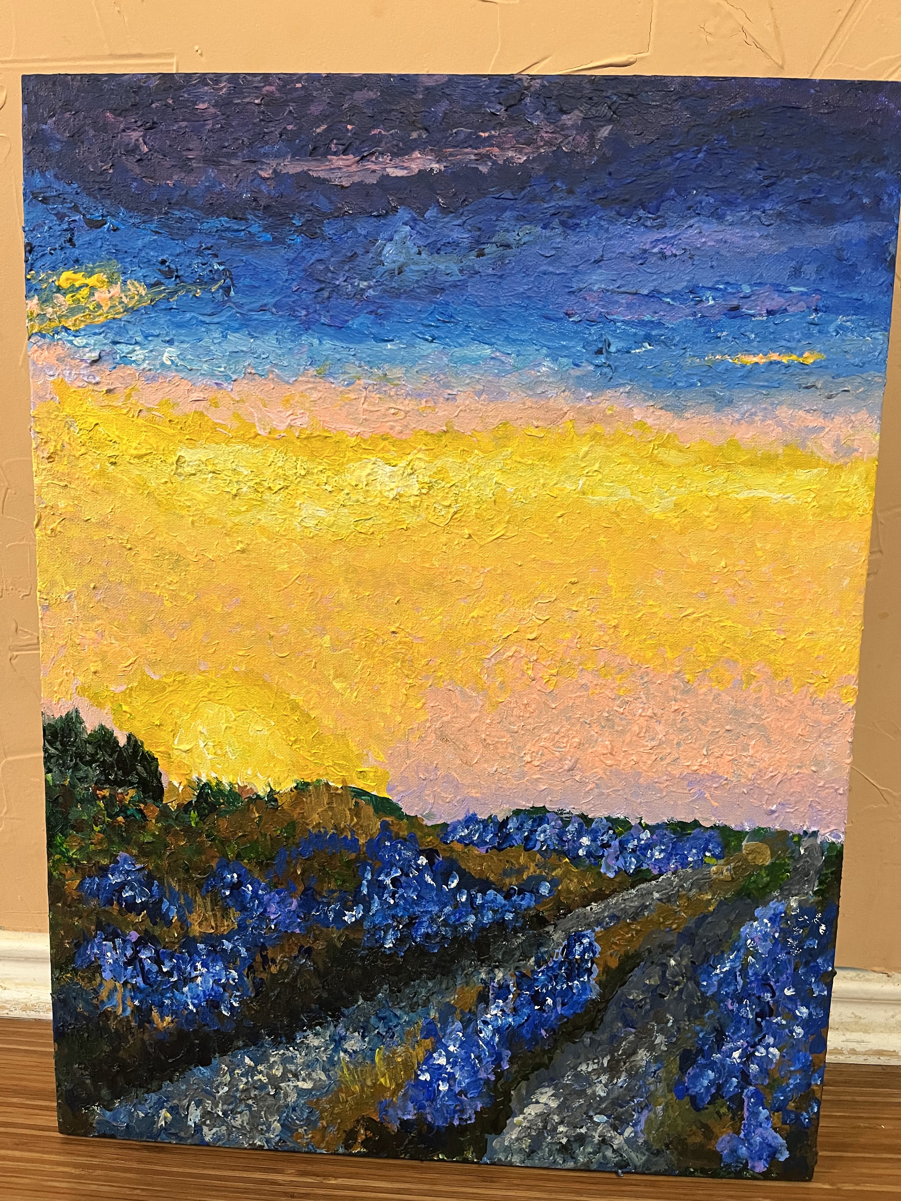 Clusters of bluebonnets on and next to a road at sunrise